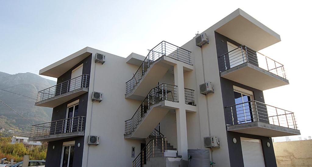 a white building with balconies on the side of it at Rosi`s Apartment in Sutomore