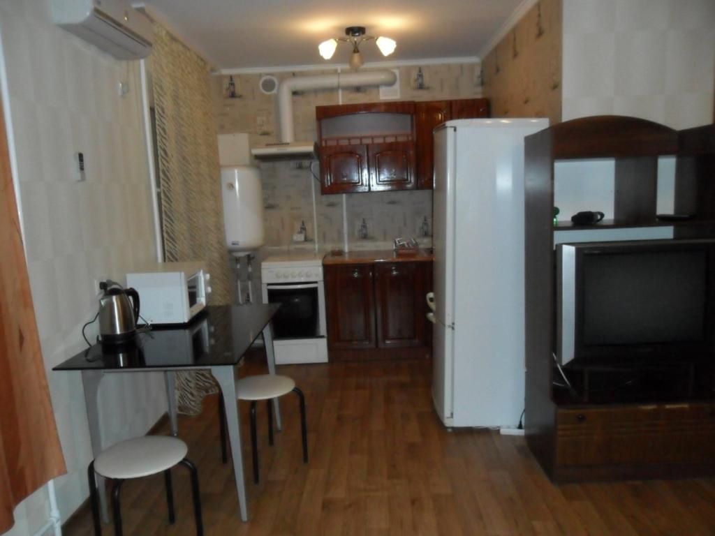 Il comprend une cuisine équipée d'une table et d'un réfrigérateur blanc. dans l'établissement проспект Олександра Поля (пр. Кірова), à Dnipro