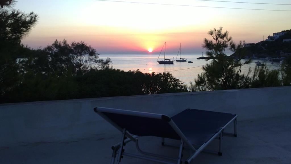 a bench on a wall with a view of a sunset at VILA INSPIRATION - ON KINI BEACH in Kinion