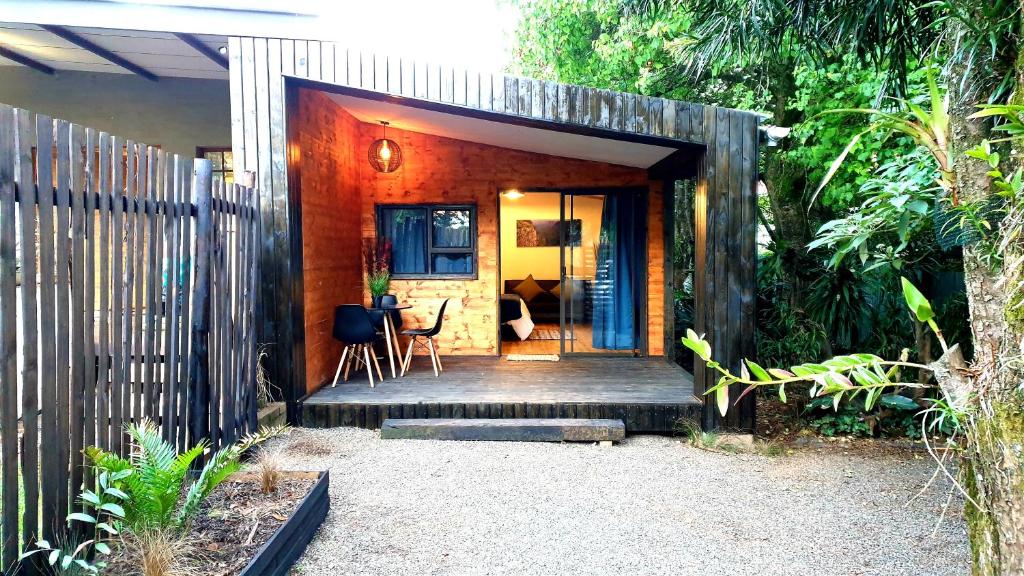 Casa pequeña con porche de madera con valla en The Elements, en Graskop