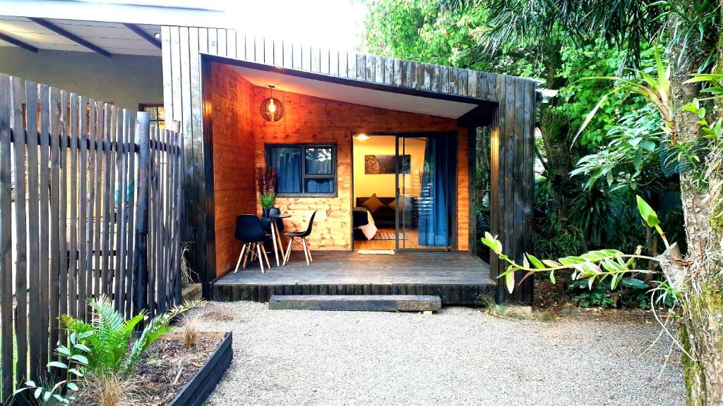 a small house with a wooden porch with a fence at The Elements in Graskop