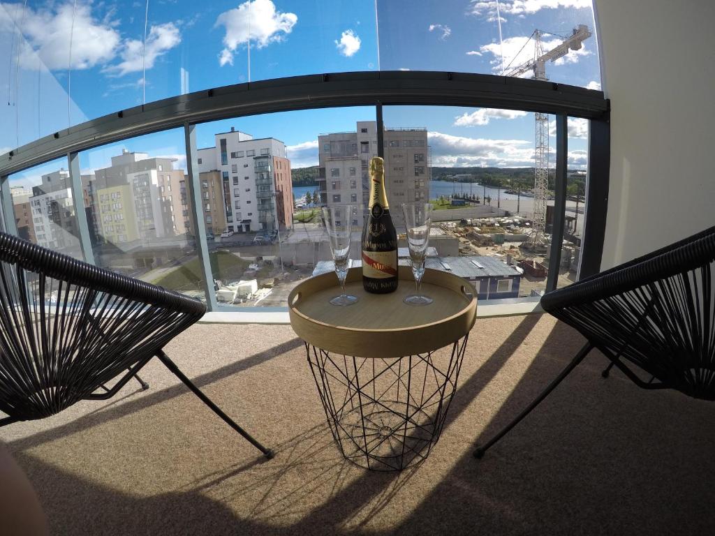 a bottle of wine on a table in front of a window at Soolo 6th floor lake view in Jyväskylä