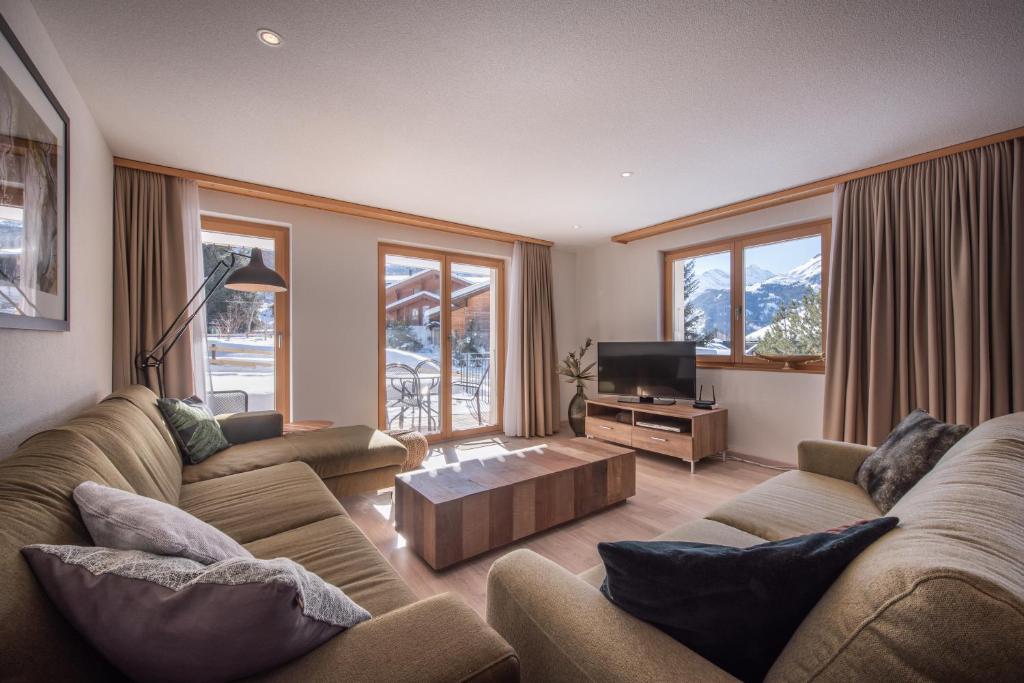 a living room with two couches and a tv at Chalet Brunner 2 in Wengen