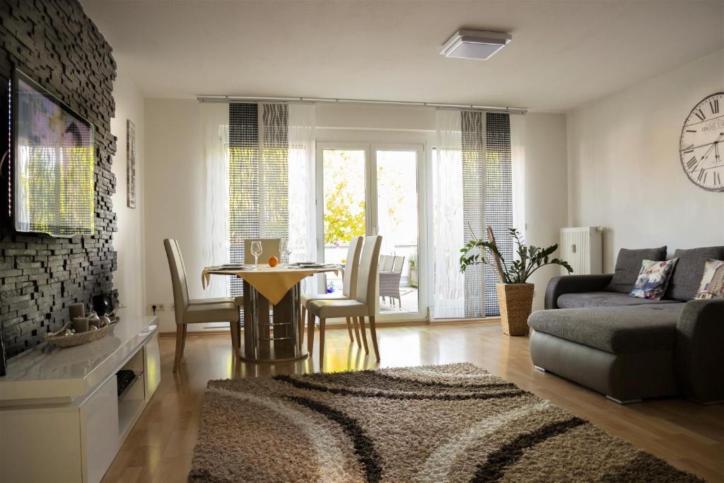 een woonkamer met een bank en een tafel met stoelen bij Apartment Lopa in Rust