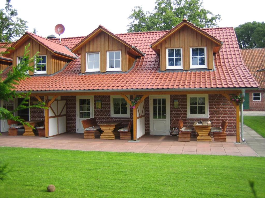 a house with a red roof and a patio at Ferienhof Drewes Ranch in Wietzendorf