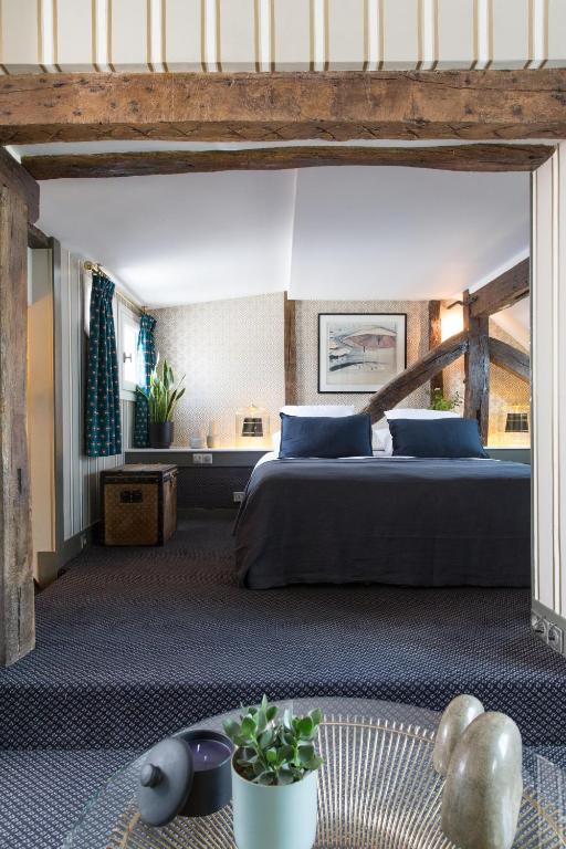a bedroom with a large bed with blue pillows at Hôtel Le Relais Saint-Germain in Paris