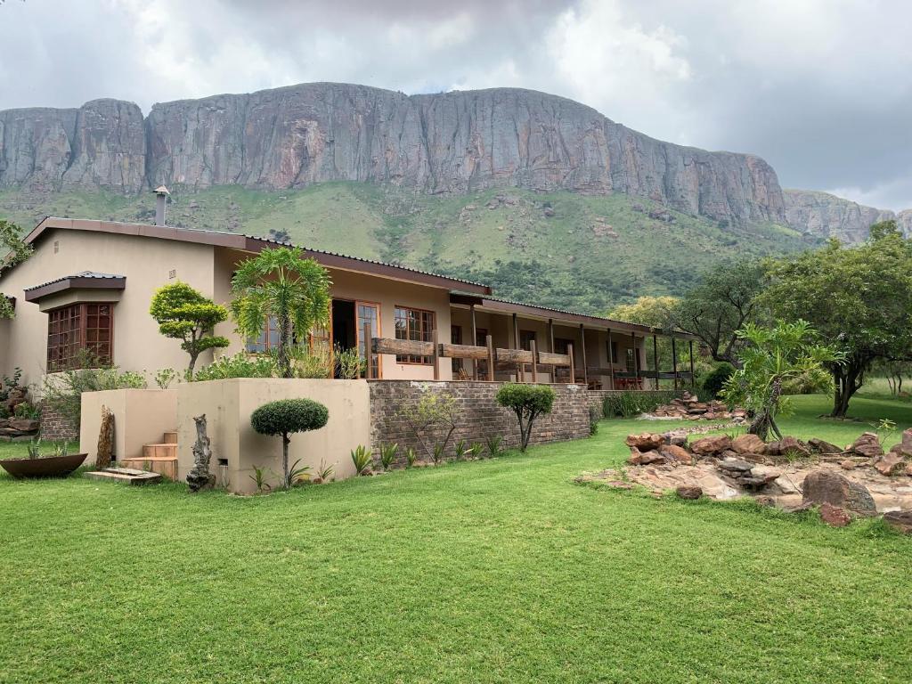 a house with a mountain in the background at Kransberg Country Lodge Guest Farm in Thabazimbi