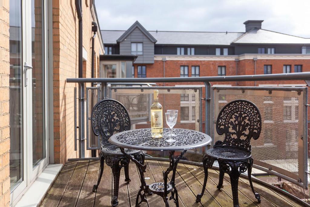 a table and chairs on a balcony with a bottle of wine at 22 John Walker House in York