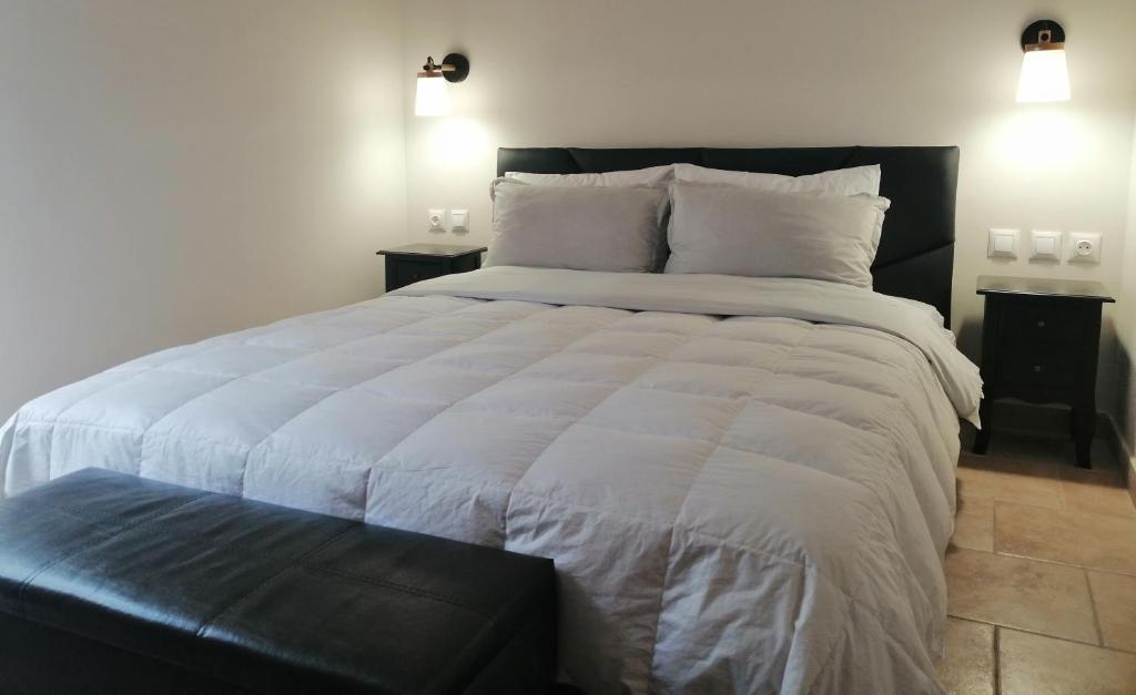 a bedroom with a large white bed with a black headboard at Luxurious Apartment in Veria