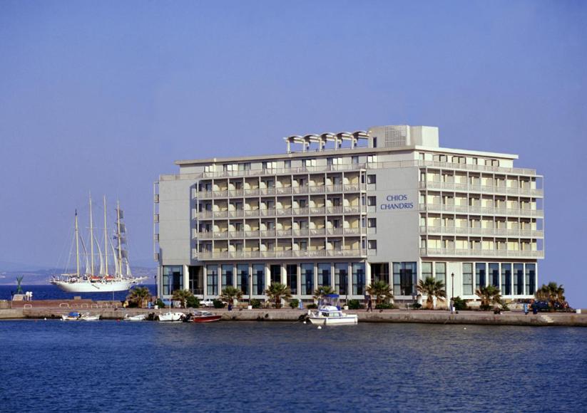 a large white building with boats in the water at Chios Chandris in Chios