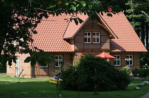 ein braunes Haus mit orangefarbenem Dach in der Unterkunft Ferienhof Wroge in Wietzendorf