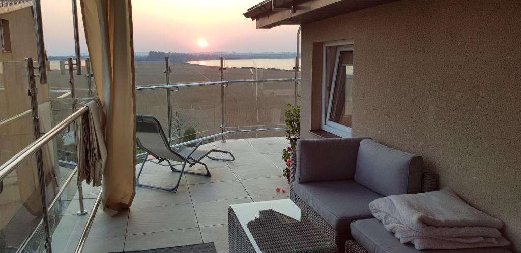 a balcony with a couch and a view of the ocean at Willa Dobryłko in Rewa