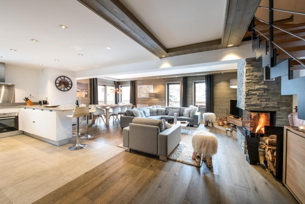 een woonkamer met een bank en een open haard bij Whistler Lodge by Alpine Residences in Courchevel