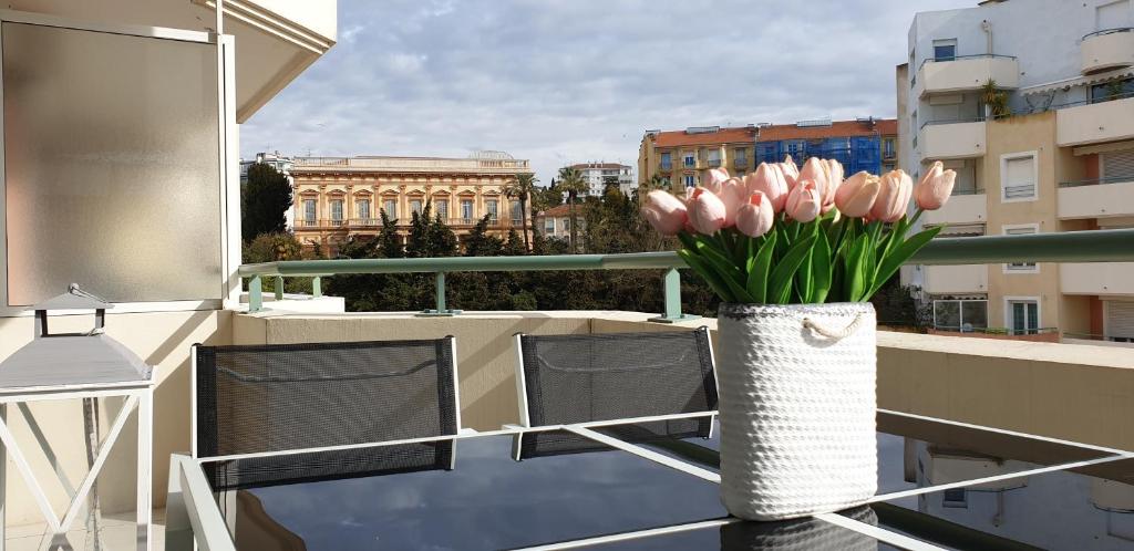 a vase of pink tulips sitting on a balcony at Alery apartment with terrace AC wifi 7th floor a few meters from the sea by Affitto-Nizza in Nice