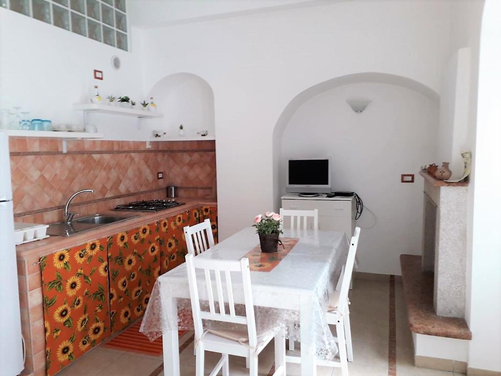 una cucina con tavolo e sedie bianchi e lavandino di Casa Martina a Peschici
