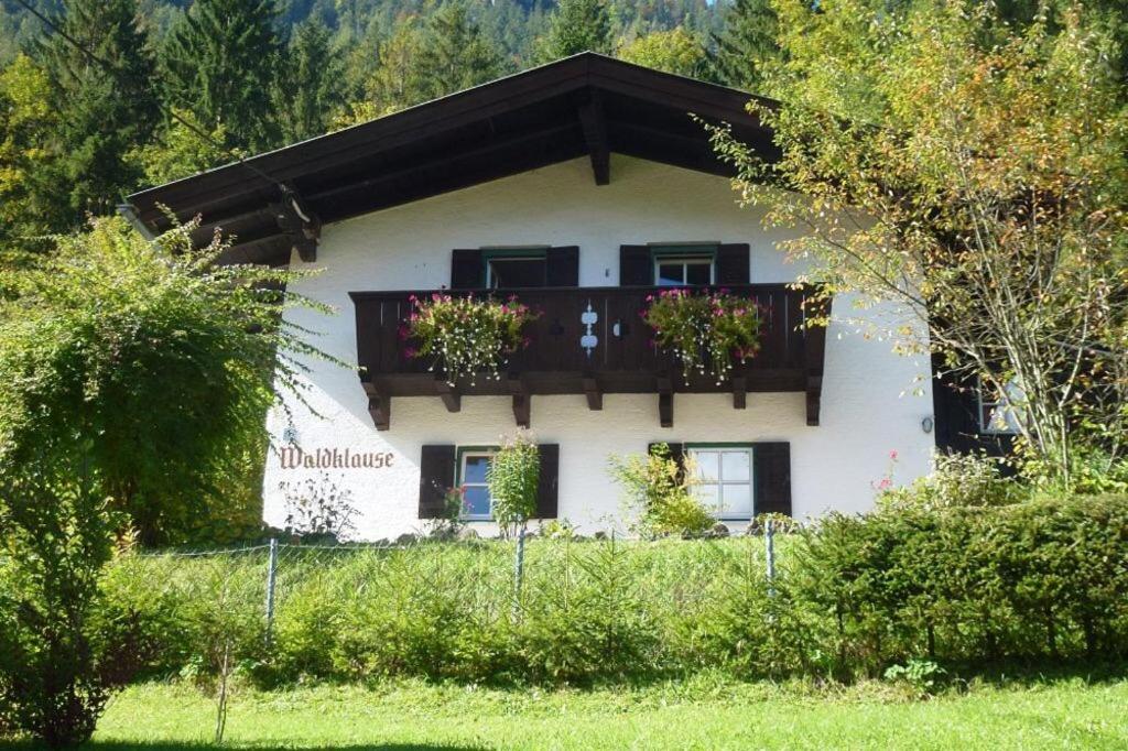 een huis met een balkon met bloemen erop bij Waldklause in Schönau am Königssee