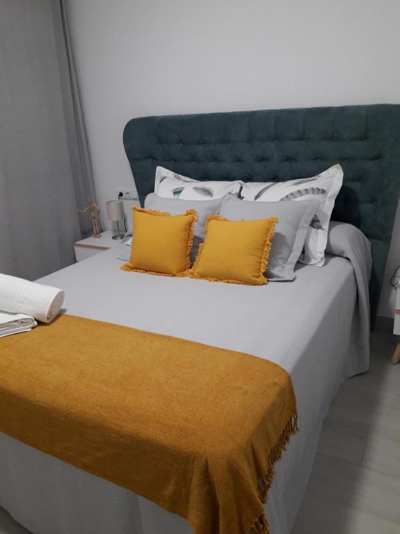 een groot bed met 2 gele kussens erop bij FUENGIROLA SWEET & BEACH in Fuengirola