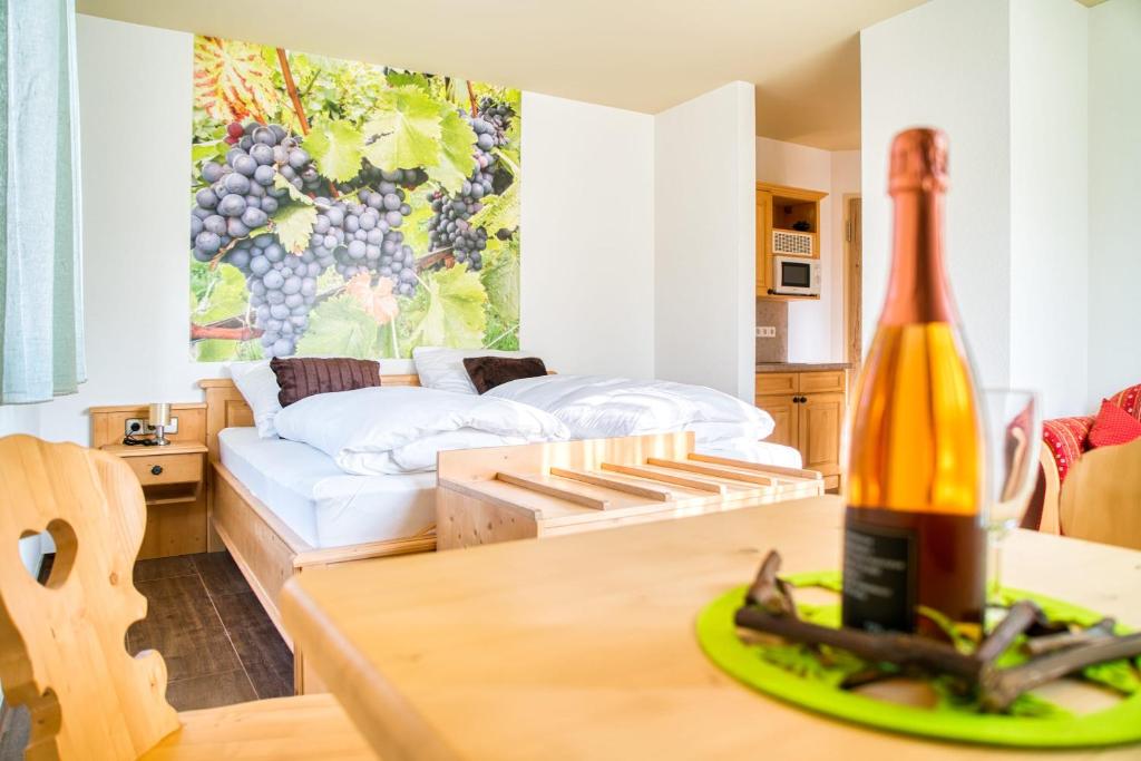 a living room with a bottle of wine on a table at Gästehaus Weingut Politschek in Bad Friedrichshall