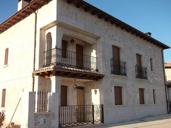 un gran edificio blanco con balcones en un lateral. en Casa Rural El Torreón II, en Caleruega