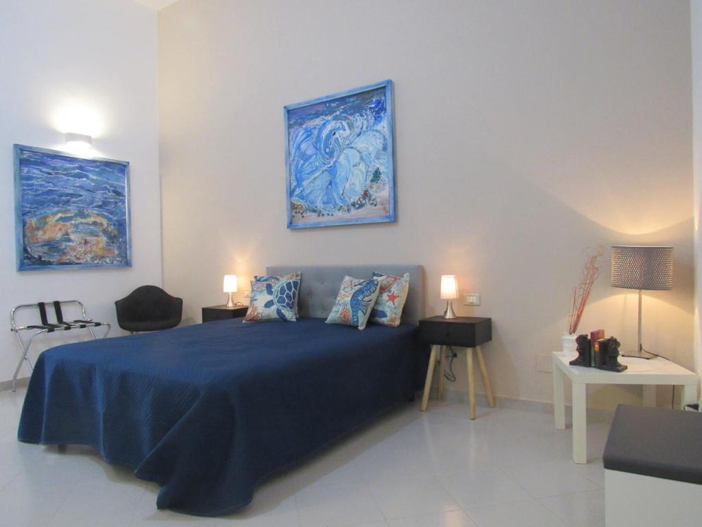 1 dormitorio con 1 cama con sábanas azules y 2 lámparas en Polpo e Polpessa Casa Vacanze, en Lipari