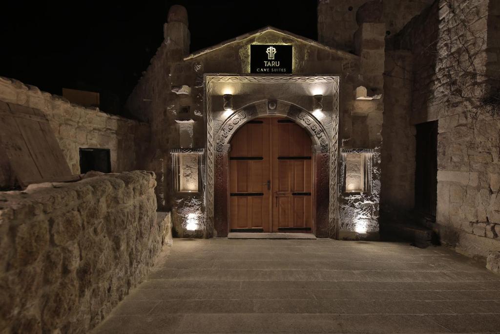 einen Eingang zu einem Steingebäude mit einer Holztür in der Unterkunft Taru Cave Suites in Ürgüp