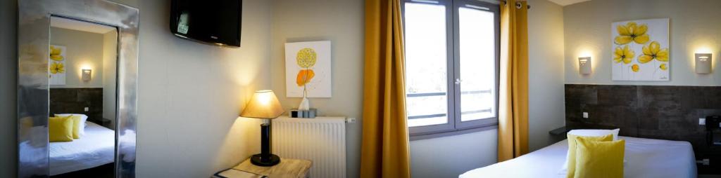 a hotel room with two beds and a window at Le Belvedere in Vallon-Pont-dʼArc