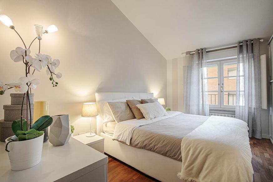 una camera bianca con un letto bianco e una finestra di J-HOME a Lucca