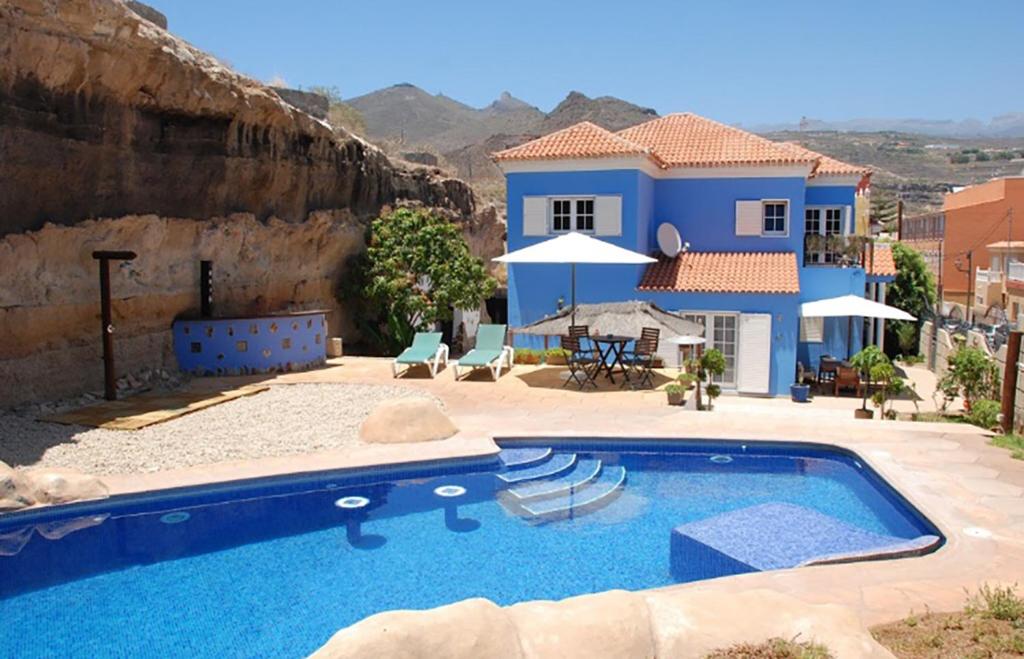 a villa with a swimming pool in front of a house at Bed & Breakfast Tenerife in San Miguel de Abona