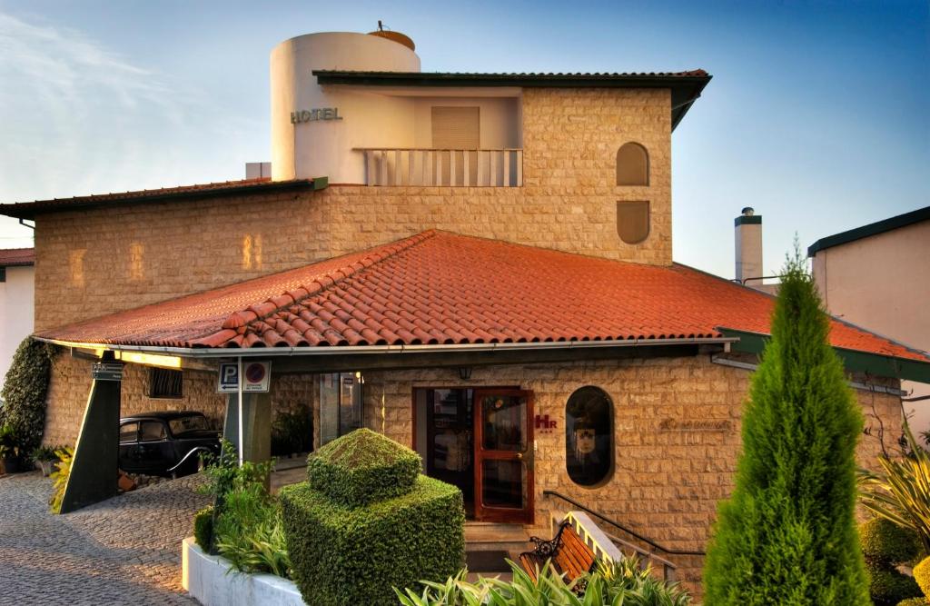 a brick house with an orange tile roof at Hotel Eurosol Seia Camelo in Seia