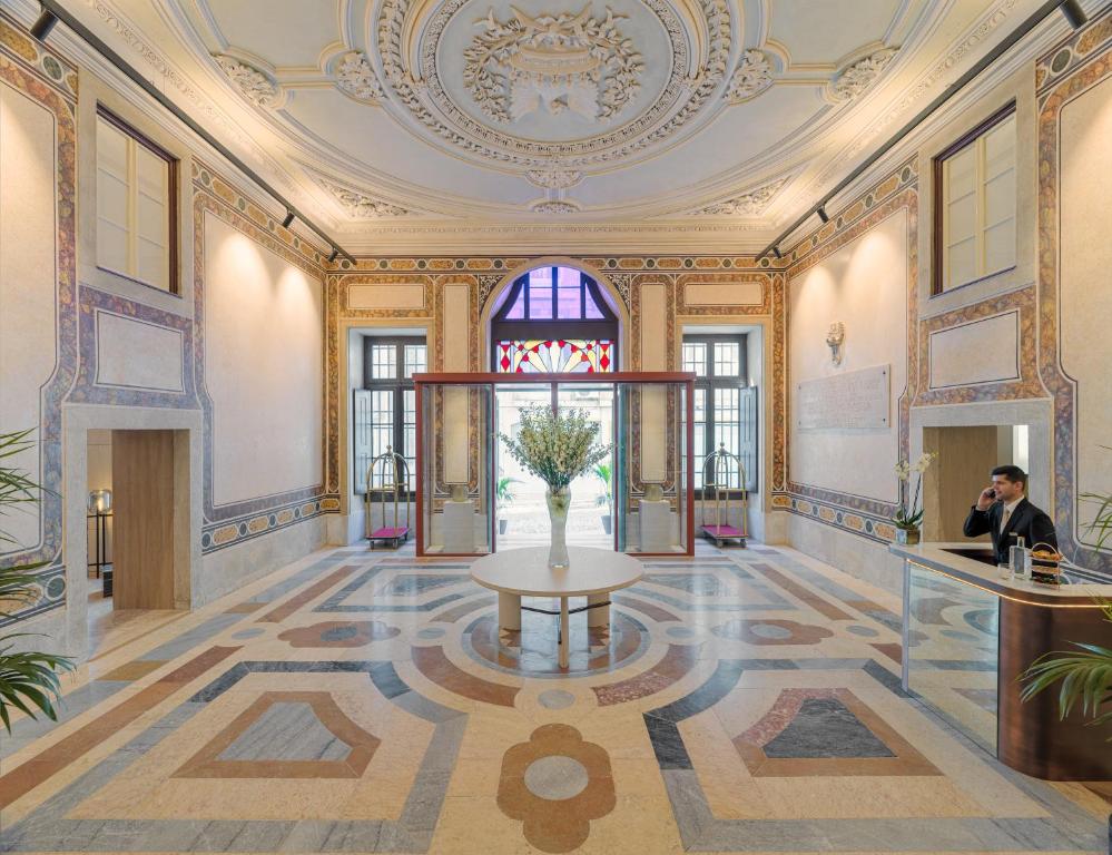 un vestíbulo con una mesa en medio de un edificio en The One Palácio da Anunciada en Lisboa