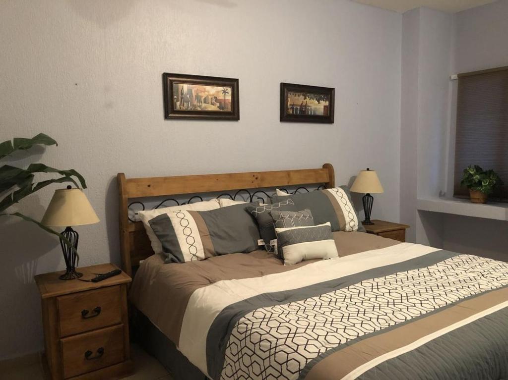 ein Bett in einem Schlafzimmer mit zwei Lampen und zwei Bildern an der Wand in der Unterkunft Sonoran Sea 1BR SSE 510 by Casago in Puerto Peñasco
