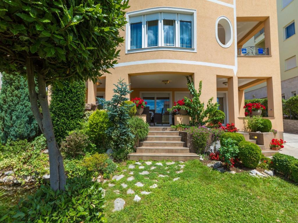 a house with a staircase leading to the front yard at Apartments Pekera in Selce