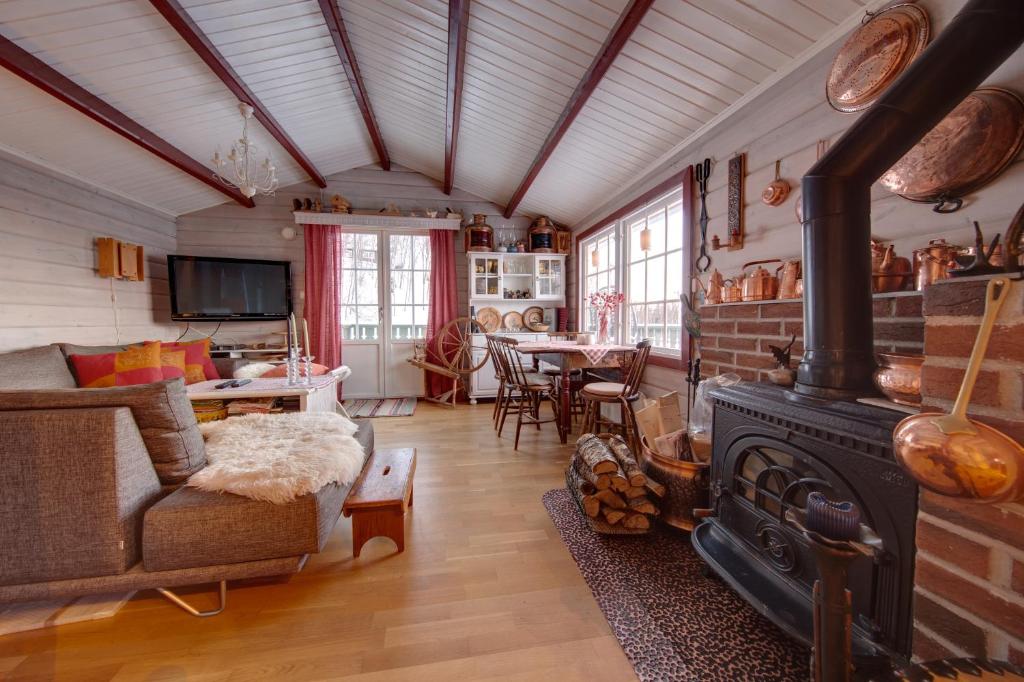 a living room with a stove and a table at Marytun Cabins in Mortenhals