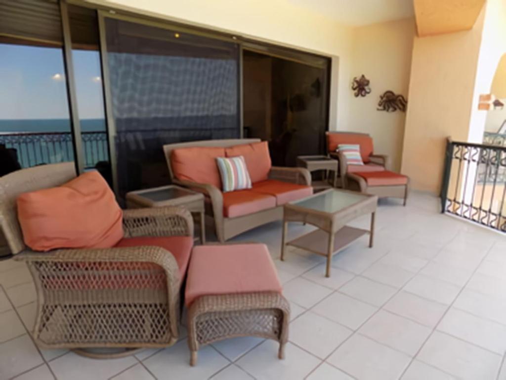 a living room with chairs and tables and a balcony at Sonoran Sea 3BR Deluxe SSW 708 by Casago in Puerto Peñasco