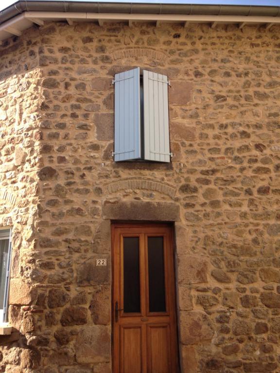 un edificio de ladrillo con una ventana y una puerta en Maison Guigon en Saint-Désirat