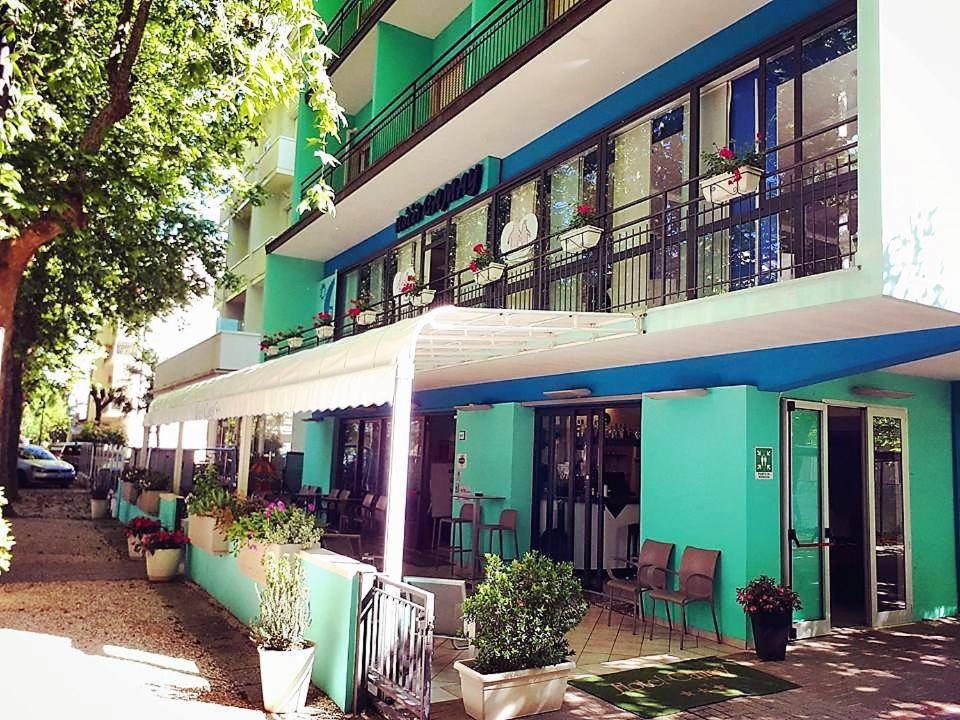 a green building with a white and blue facade at Hotel Camay in Cesenatico