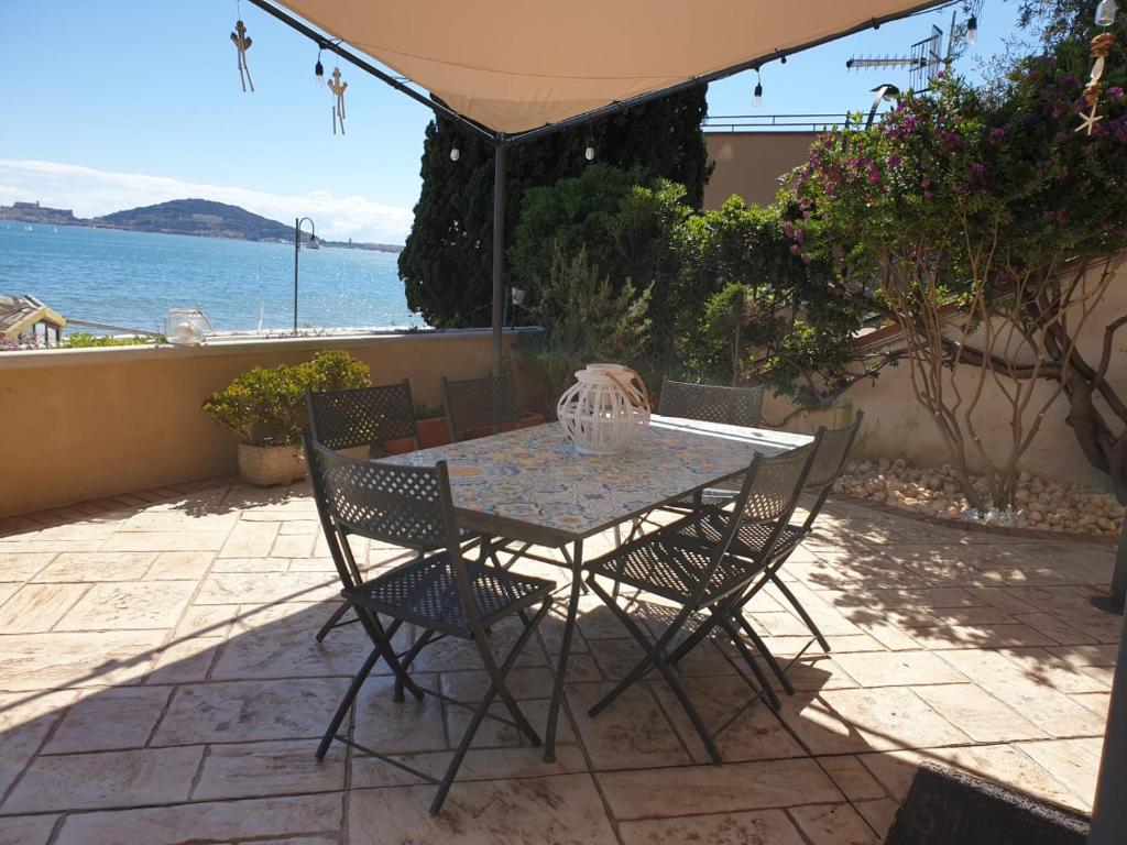 una mesa y sillas en un patio con vistas al océano en Residenza Gli Oleandri, en Formia