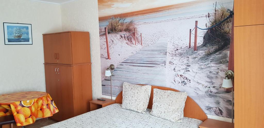 a bedroom with a painting of a pier at Apartament Belvedere in Olimp