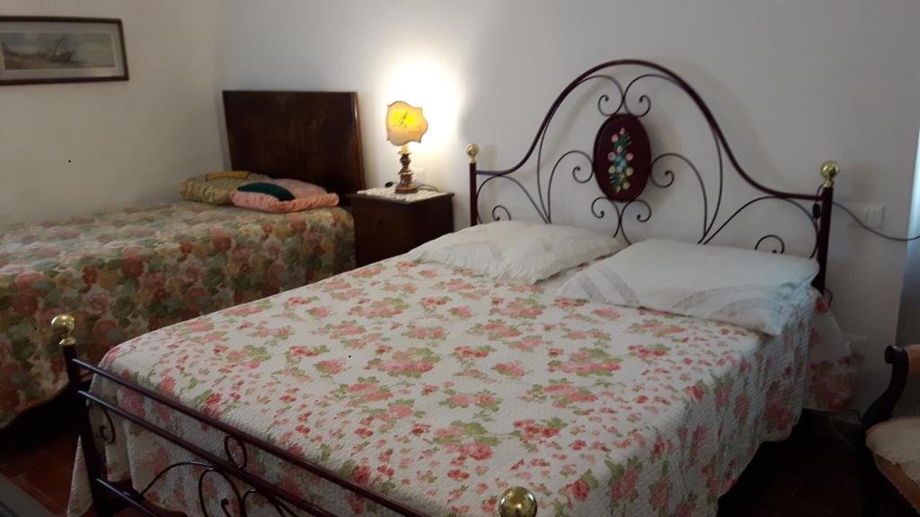 1 dormitorio con 2 camas con colcha de flores en Casa Sassa, en Sassa