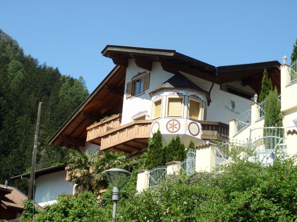 uma casa grande com uma varanda ao lado em Hotel Gurschler em San Leonardo in Passiria