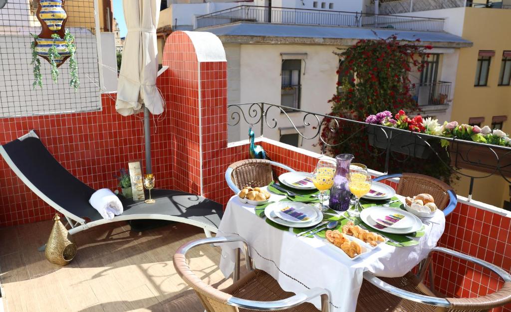 une table avec des assiettes de nourriture sur un balcon dans l'établissement Casa Isa, à Valence