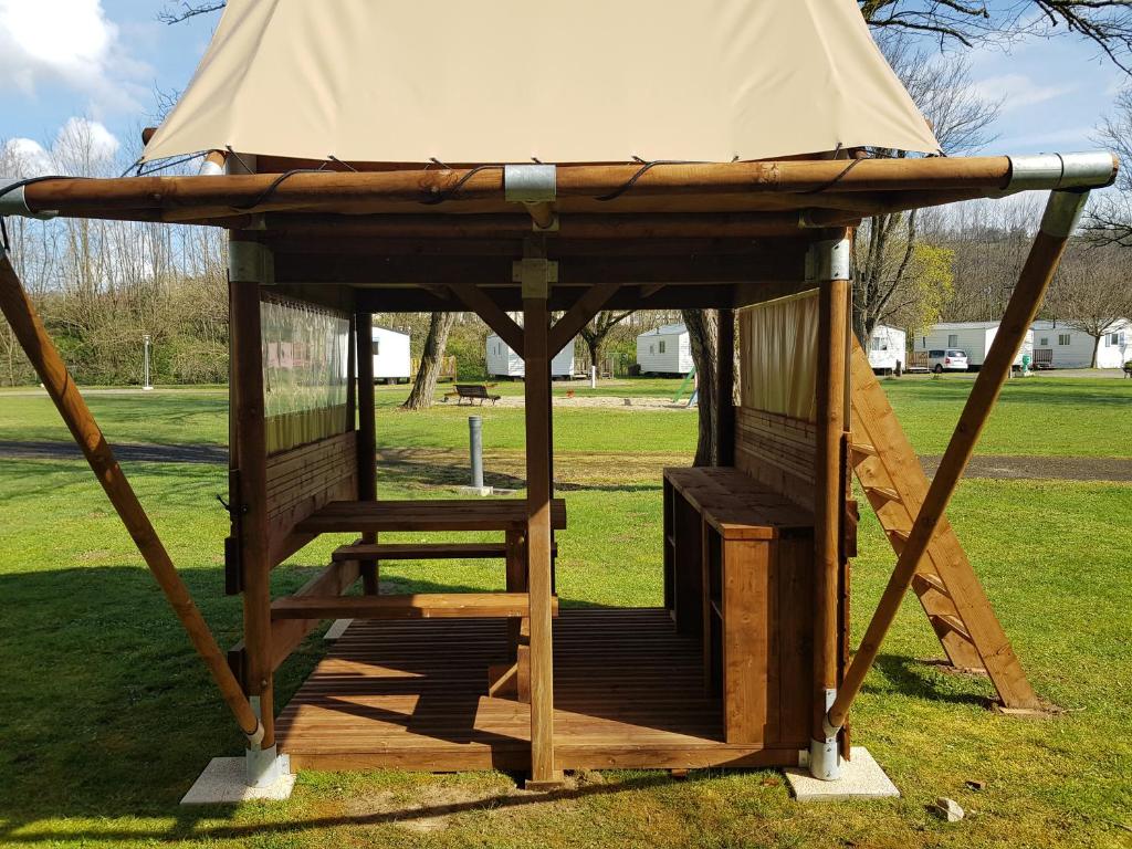 einen hölzernen Pavillon mit einem Stuhl im Gras in der Unterkunft Les Berges Du Cele in Bagnac