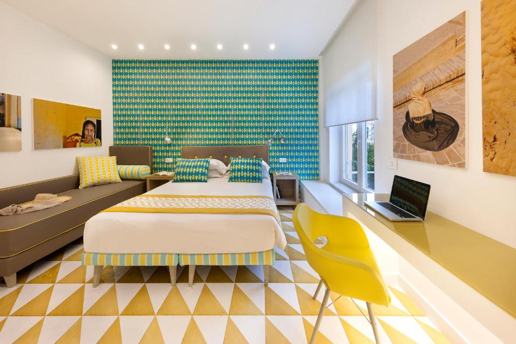una camera con due letti e un divano di Casa Dominova de Luxe a Sorrento