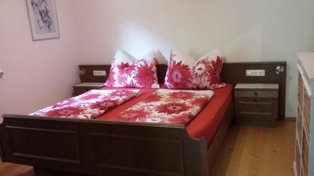 a bedroom with a bed with red sheets and pillows at Ferienhaus Edelweiss in Sankt Kanzian