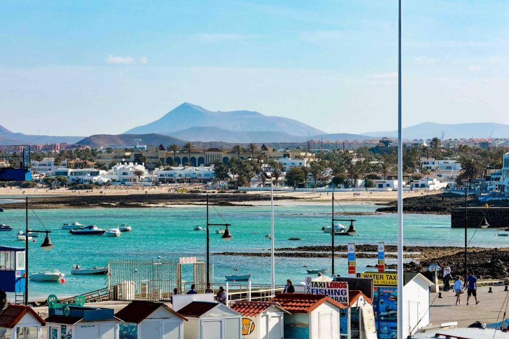 a view of a beach with boats in the water at La Buena Vida, by Comfortable Luxury in Corralejo
