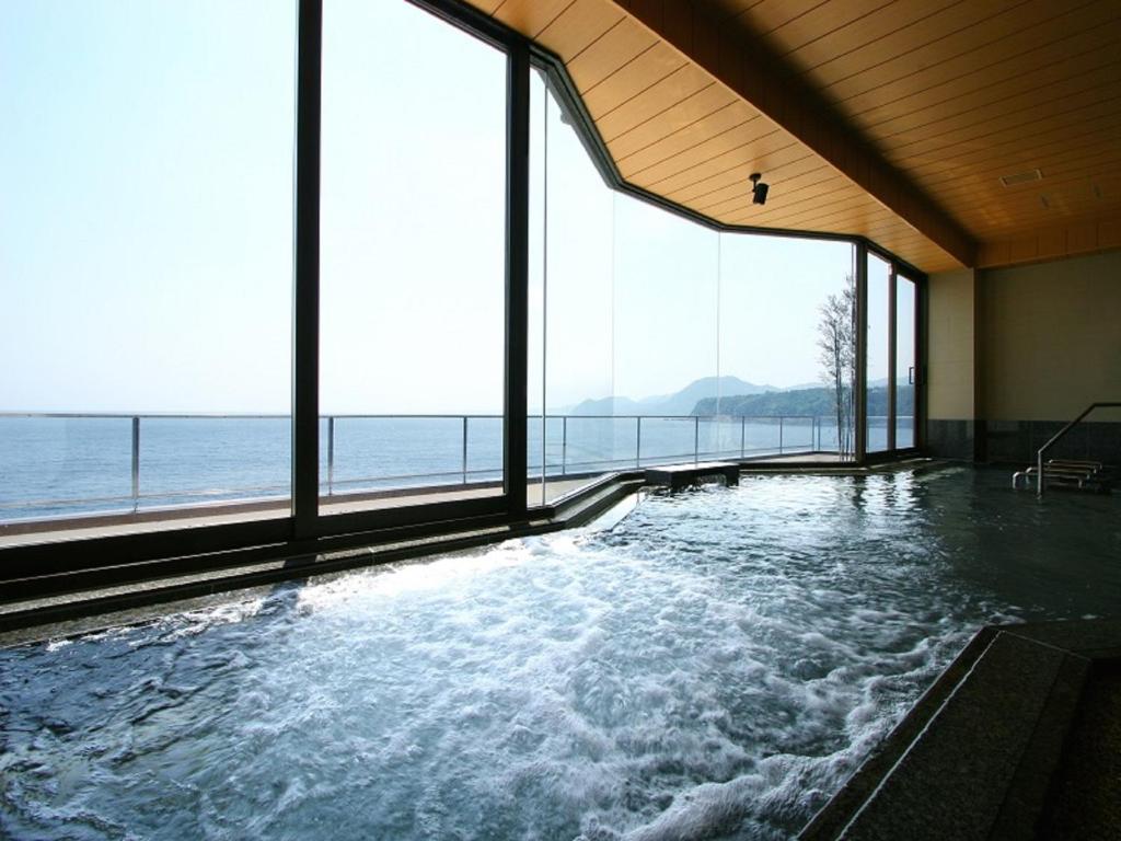 a large swimming pool with a view of the ocean at Inatori Tokai Hotel Yuen in Higashiizu