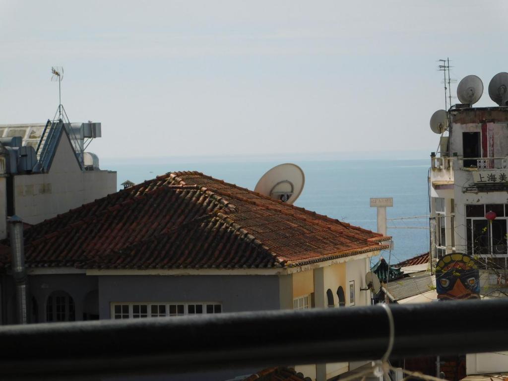 Blick auf die Dächer von Gebäuden und ein Schiff in der Unterkunft Tropical Rocha Residence in Portimão