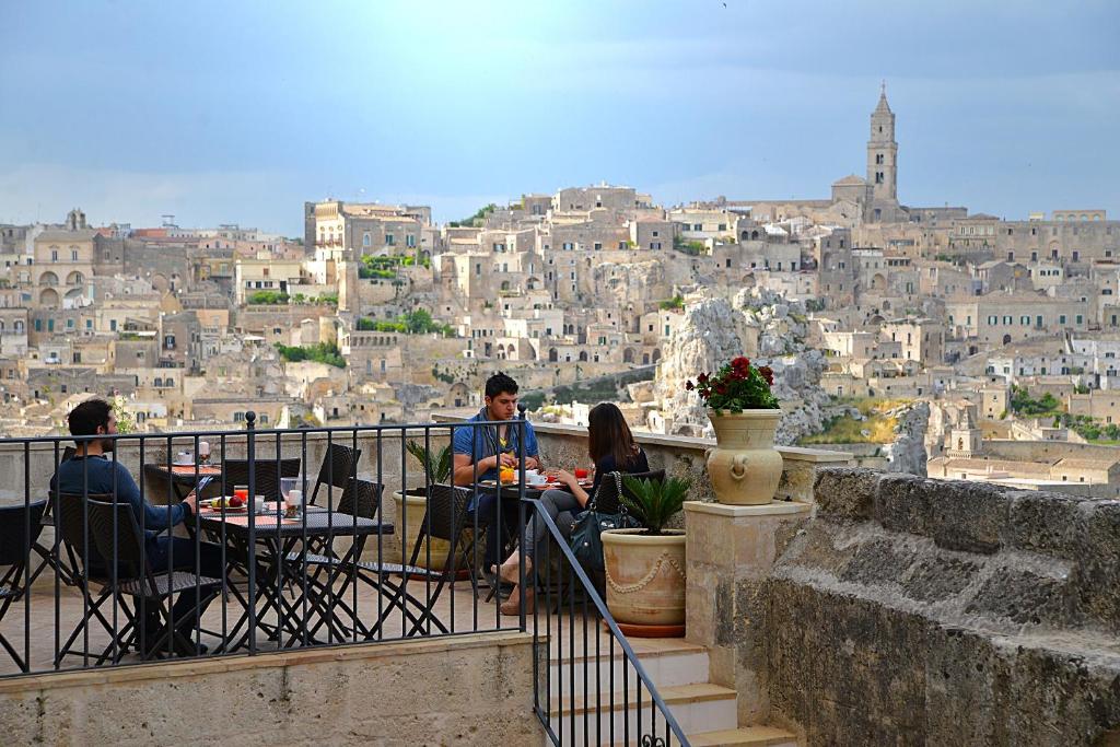 a group of people sitting at tables looking at a city at Il Belvedere in Matera