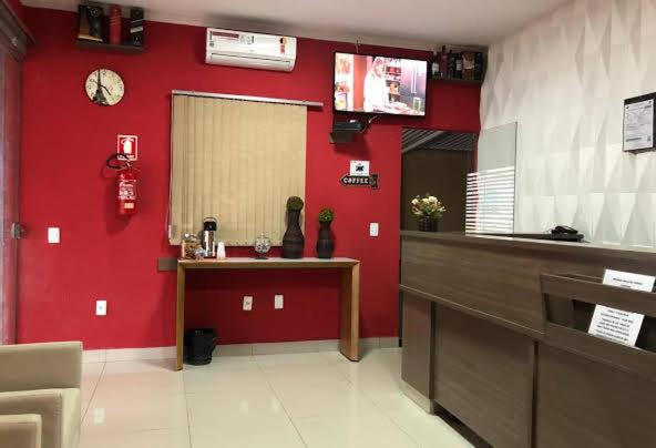 a kitchen with a red wall with a counter and a fire hydrant at POUSADA EXECUTIVE EXPRESS in Goiânia