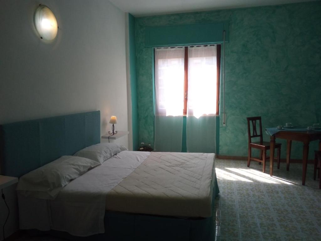 Bed & Breakfast LA TERRAZZA في لاتينا: غرفة نوم بسرير وطاولة ونافذة